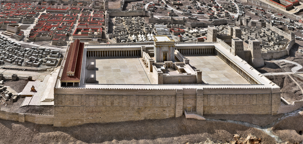 Un modelo detallado que representa un antiguo complejo de templos rodeado por una muralla fortificada, ubicado dentro de un paisaje urbano histórico meticulosamente reconstruido con varias estructuras y calles.