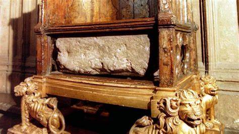El rey Carlos III se sienta en la piedra cortada con las manos.