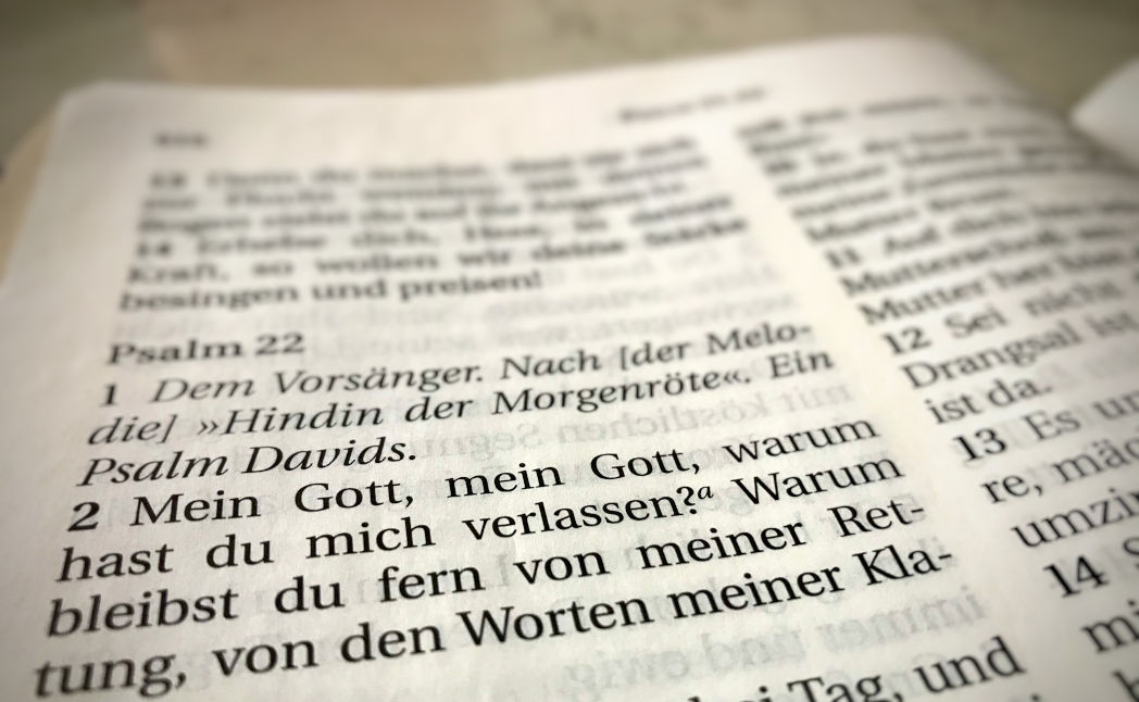 Nahaufnahme einer geöffneten Bibelseite auf Deutsch, die Psalmen zeigt, mit Fokus auf Psalm 22, der als "Psalm Davids" bezeichnet wird.